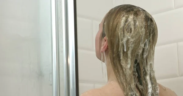 Mooie jonge vrouw die een douche neemt — Stockfoto