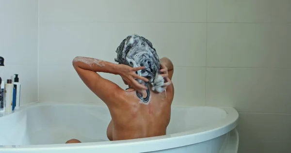 Bella donna che fa il bagno, lavandosi i capelli. — Foto Stock