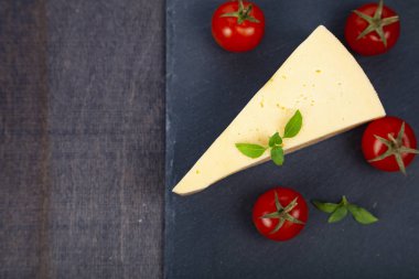 Peynir, domates ve fesleğen karanlık bir arka plan üzerinde.