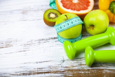 Gıda diyet ve ahşap arka plan üzerinde halter. Diyet ve sağlıklı yaşam kavramı.