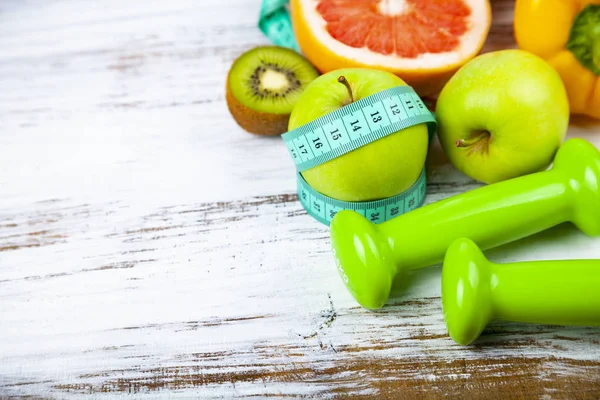 Gıda diyet ve ahşap arka plan üzerinde halter. Diyet ve sağlıklı yaşam kavramı.