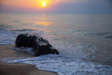 Günbatımı güzel denizde. Sprey ve günlük sarı güneşin arka planı. Deniz manzarası.