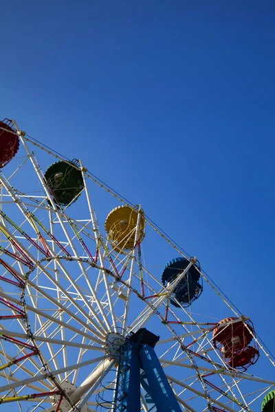 Ferris wheel against the blue sky. Amusement park.