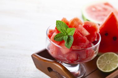 Karpuz ve nane ahşap bir masa üzerinde bir tabak içinde parçalar. Lezzetli tatlı.