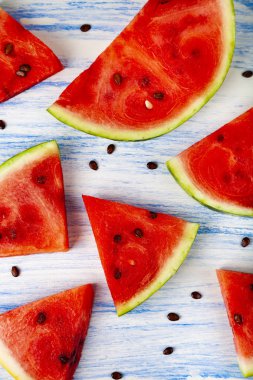 Karpuz mavi ahşap bir masa üstten görünüm üzerinde parçaları. Lezzetli tatlı.