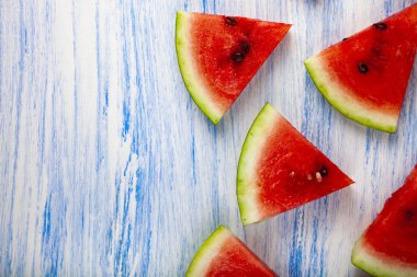 Karpuz mavi ahşap bir masa üstten görünüm üzerinde parçaları. Lezzetli tatlı. Metniniz için yer.