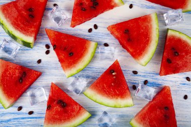 Karpuz ve mavi ahşap bir masa üstten görünüm buza parçalar. Lezzetli tatlı.