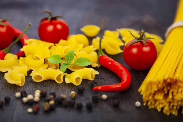 Pastas Diferentes Sobre Fondo Madera Oscura Pastas Crudas Chile Tomates —  Fotos de Stock