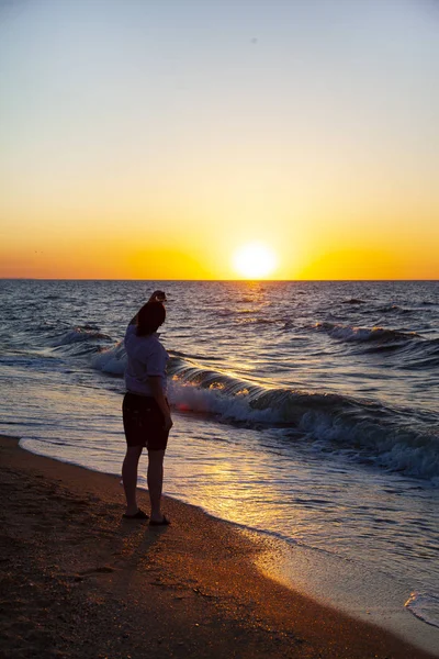 Teenager with action camera the sea at sunset