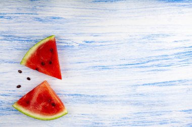 Karpuz mavi ahşap bir masa üstten görünüm üzerinde iki adet. Lezzetli tatlı.