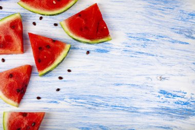 Karpuz mavi ahşap bir masa üstten görünüm üzerinde parçaları. Lezzetli tatlı.