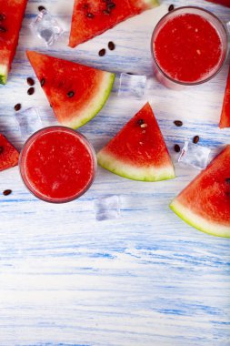 Karpuz suyu ve buz üzerinde mavi ahşap bir masa üstten görünüm. Lezzetli ferahlatıcı içeceği.