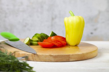 Sebze salatası, bıçak ve kesme tahtası masanın üzerinde. Yemek hazırlanması.