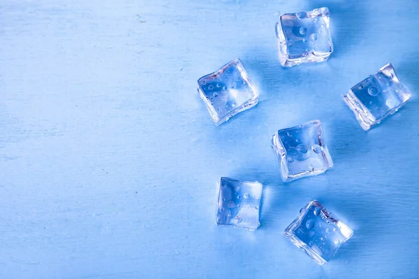 Ijsblokjes Een Blauwe Houten Achtergrond — Stockfoto