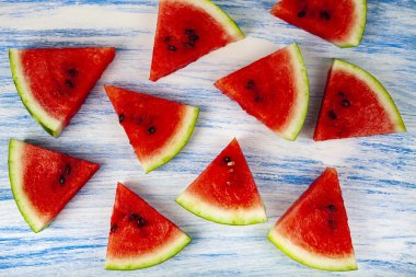 Karpuz mavi ahşap bir masa üstten görünüm üzerinde parçaları. Lezzetli tatlı.
