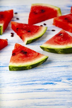 Karpuz mavi ahşap bir masa üzerinde parçaları. Lezzetli tatlı.