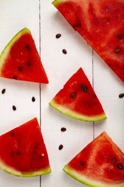 Beyaz ahşap bir masa üstten görünüm üzerinde karpuz parçalar. Lezzetli tatlı.
