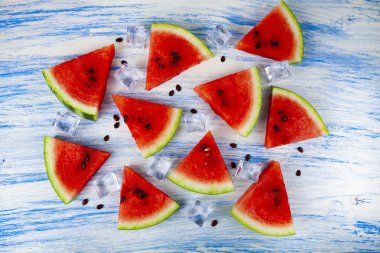 Karpuz ve mavi ahşap bir masa üstten görünüm buza parçalar. Lezzetli tatlı.