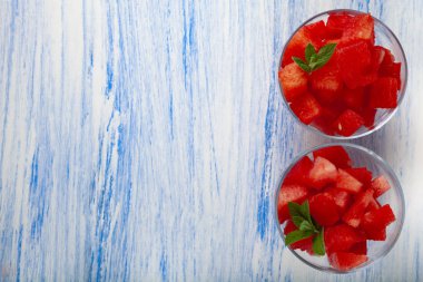 Karpuz ve nane bir plaka üzerinde ahşap bir masa, üstten görünüm parçalar. Lezzetli tatlı.