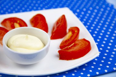 Lezzetli domates ve mavi renkli bir tabağa sos