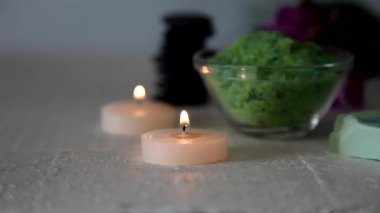 Mumlar, spa taşları, deniz tuzu ve orkide masanın üzerine yazma.