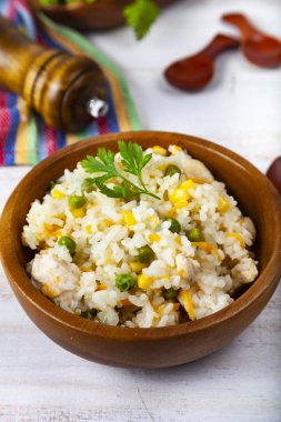 Masanın üzerinde bir ahşap kase sebze ile haşlanmış pirinç. Lezzetli vejetaryen yemek.