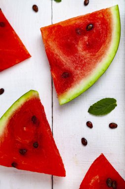 Karpuz ve nane Beyaz ahşap bir masa üstten görünüm üzerinde parçalar. Lezzetli tatlı.