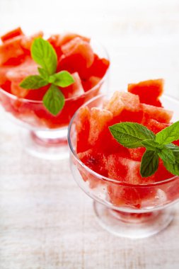 Karpuz ve nane ahşap bir masa üzerinde bir tabak içinde parçalar. Lezzetli tatlı.