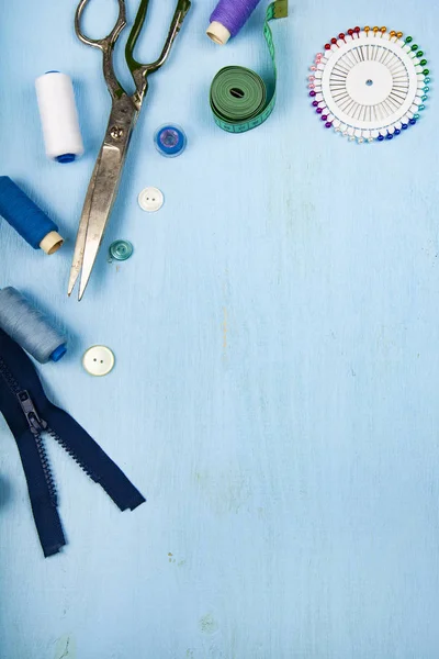 ミシン アクセサリー青い木製の背景に 測定テープ ボタン ジッパー はさみ — ストック写真