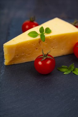 Peynir, domates ve fesleğen karanlık bir arka plan üzerinde.