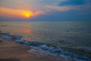 Günbatımı güzel denizde. Sarı güneşin arka plan üzerinde sprey. Deniz manzarası.
