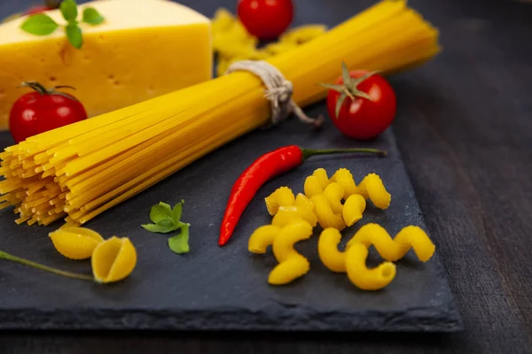 Massa Queijo Diferentes Fundo Madeira Escura Macarrão Cru Pimentão Tomate — Fotografia de Stock