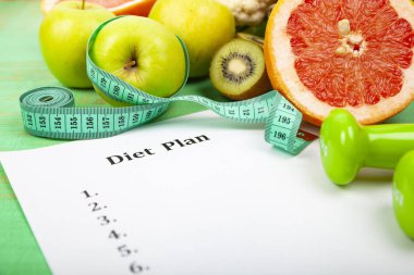 Gıda ve sayfaya yeşil ahşap arka plan üzerinde bir diyet planı. Diyet ve sağlıklı yaşam kavramı.