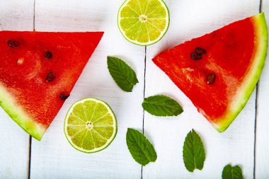 Karpuz, nane ve limon Beyaz ahşap bir masa üstten görünüm üzerinde parçalar. Lezzetli tatlı.