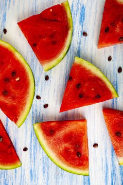 Karpuz mavi ahşap bir masa üzerinde parçaları. Lezzetli tatlı.