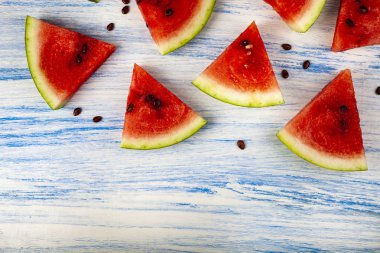 Karpuz mavi ahşap bir masa üzerinde parçaları. Lezzetli tatlı.