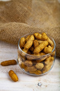Ahşap bir masa üzerinde bir açık cam kavanoz fıstık. Lezzetli ve sağlıklı fındık.
