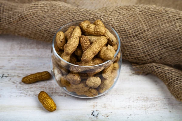 Amendoins Jarro Vidro Aberto Uma Mesa Madeira Nozes Deliciosas Saudáveis — Fotografia de Stock