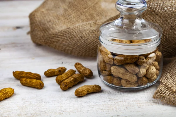 Amendoins Frasco Vidro Fechado Uma Mesa Madeira Nozes Deliciosas Saudáveis — Fotografia de Stock