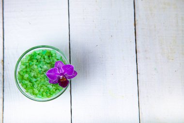 Spa uygulamaları ahşap masa üzerinde. Deniz tuz ve orkide yakın çekim.