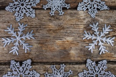 Gümüş kar tanesi bir eski kahverengi ahşap zemin üzerinde. Noel çerçeve.