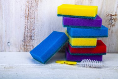 Ahşap arka plan üzerinde bulaşık için çok renkli süngerler.