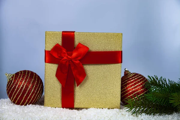 Kırmızı Noel hediyesi, Ladin şube ve kar topları. Noel ve yeni yıl için dekor.