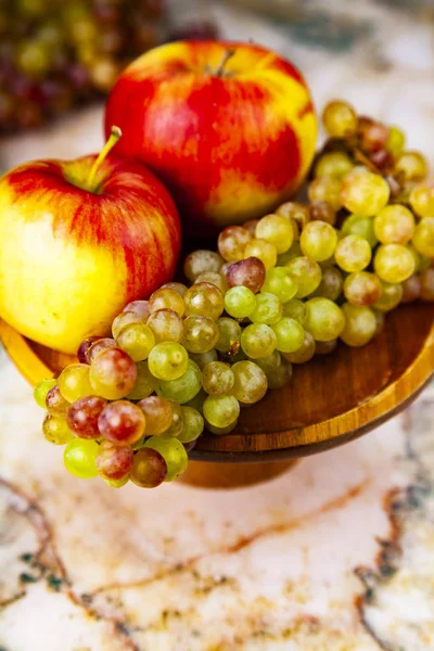 Trauben Und Äpfel Einer Hölzernen Schale Auf Einem Marmortisch — Stockfoto