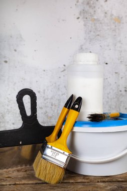 Öğeleri gri bir duvara ev ya da ofis tadilat için. Boya ve masanın üzerine fırça.