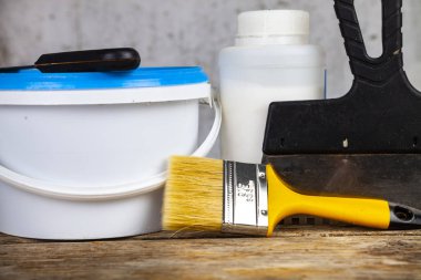 Öğeleri gri bir duvara ev ya da ofis tadilat için. Boya ve masanın üzerine fırça.