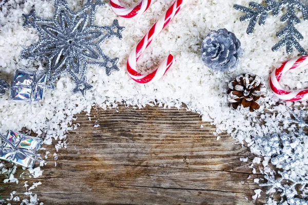 Zilverkleurige Sneeuwvlokken Geschenken Snoep Sneeuw Een Oud Bruin Houten Achtergrond — Stockfoto