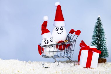 Kar üzerinde bir alışveriş sepeti Noel kapaklar iki yumurta. Noel alışveriş. Noel satış.