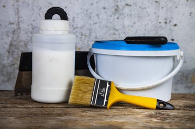  Boya ve masanın üzerine fırça. Gri bir duvara ev ya da ofis tadilat için öğeleri.