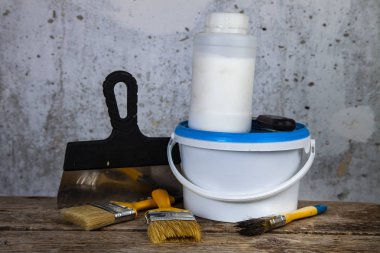  Boya ve masanın üzerine fırça. Gri bir duvara ev ya da ofis tadilat için öğeleri.